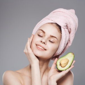 Shows a lady holding an avocado with fresh, blemish free skin.